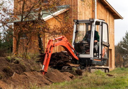 Bannerbild mit einem roten Bagger der für den Ggartenbau eingesetzt wird